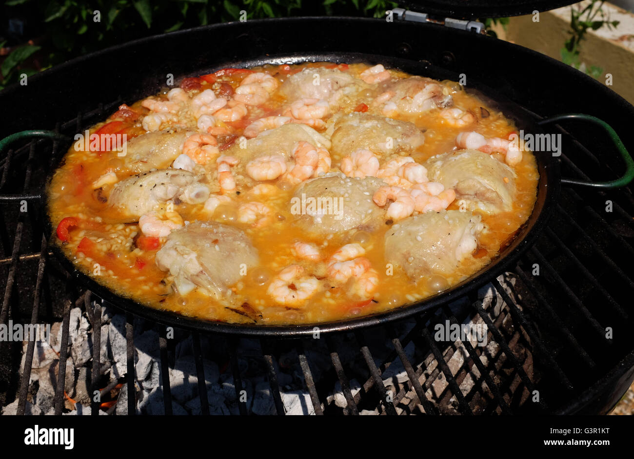 Prawn and chicken paella being cooked outside on a barbecue on hot