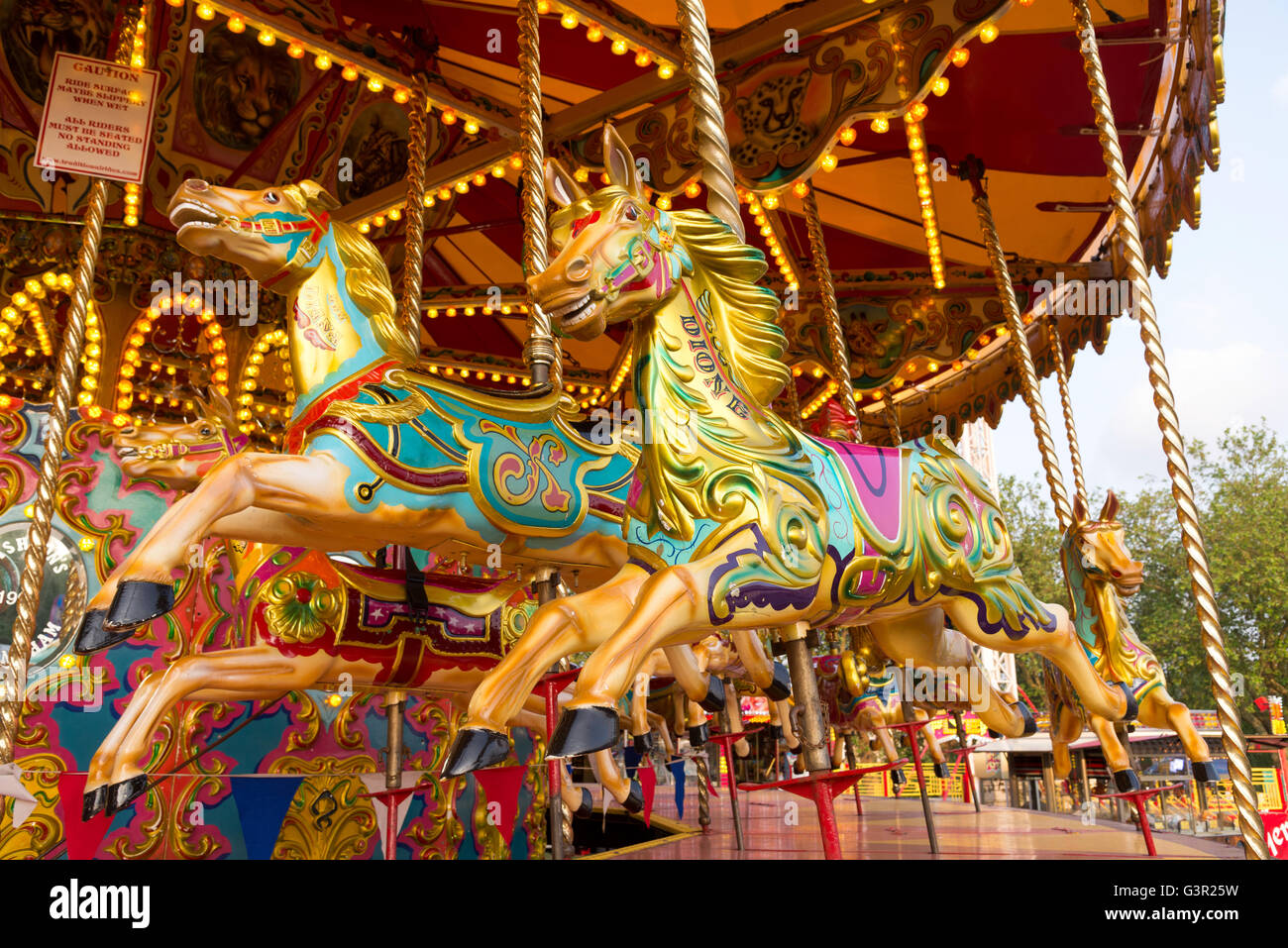 Horses of an old fashioned carousel ride in fairground, England, UK Stock Photo