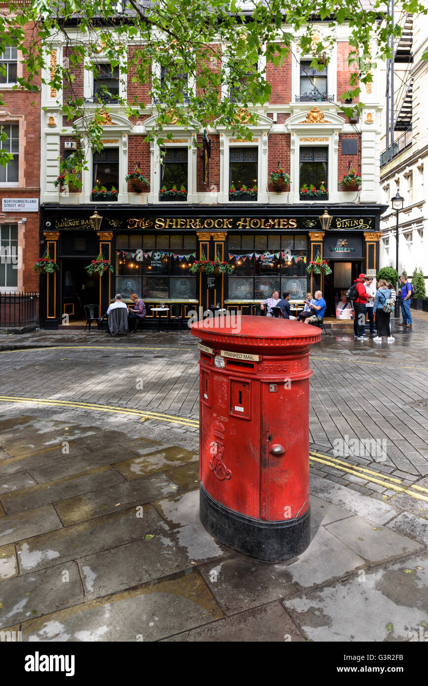 Red post box by the the Sherlock Holes pub, Westminster, London, UK. Stock Photo