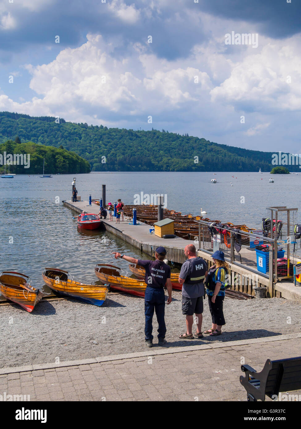 Tourists hiring a traditional wooden skiff and self drive motor boats at Bowness Windermere Cumbria Stock Photo