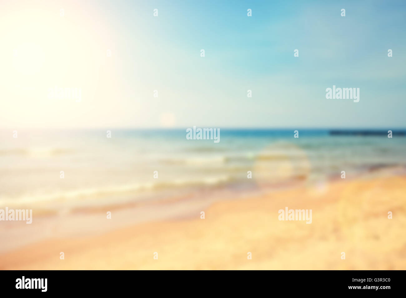 Blurred beach with lens flare effect, nature background. Stock Photo