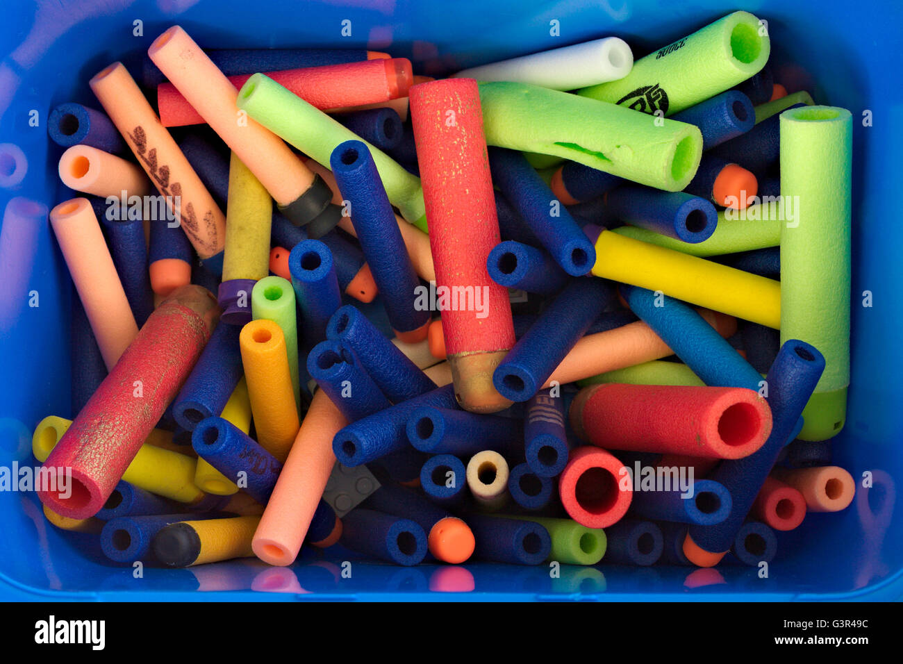 Foam toy Nerf gun darts in multiple colors in a blue box. Stock Photo