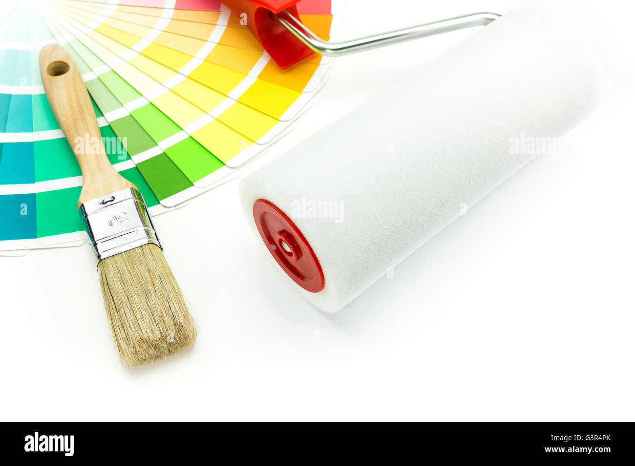 Paint roller, brush and color sample catalog on white background Stock Photo