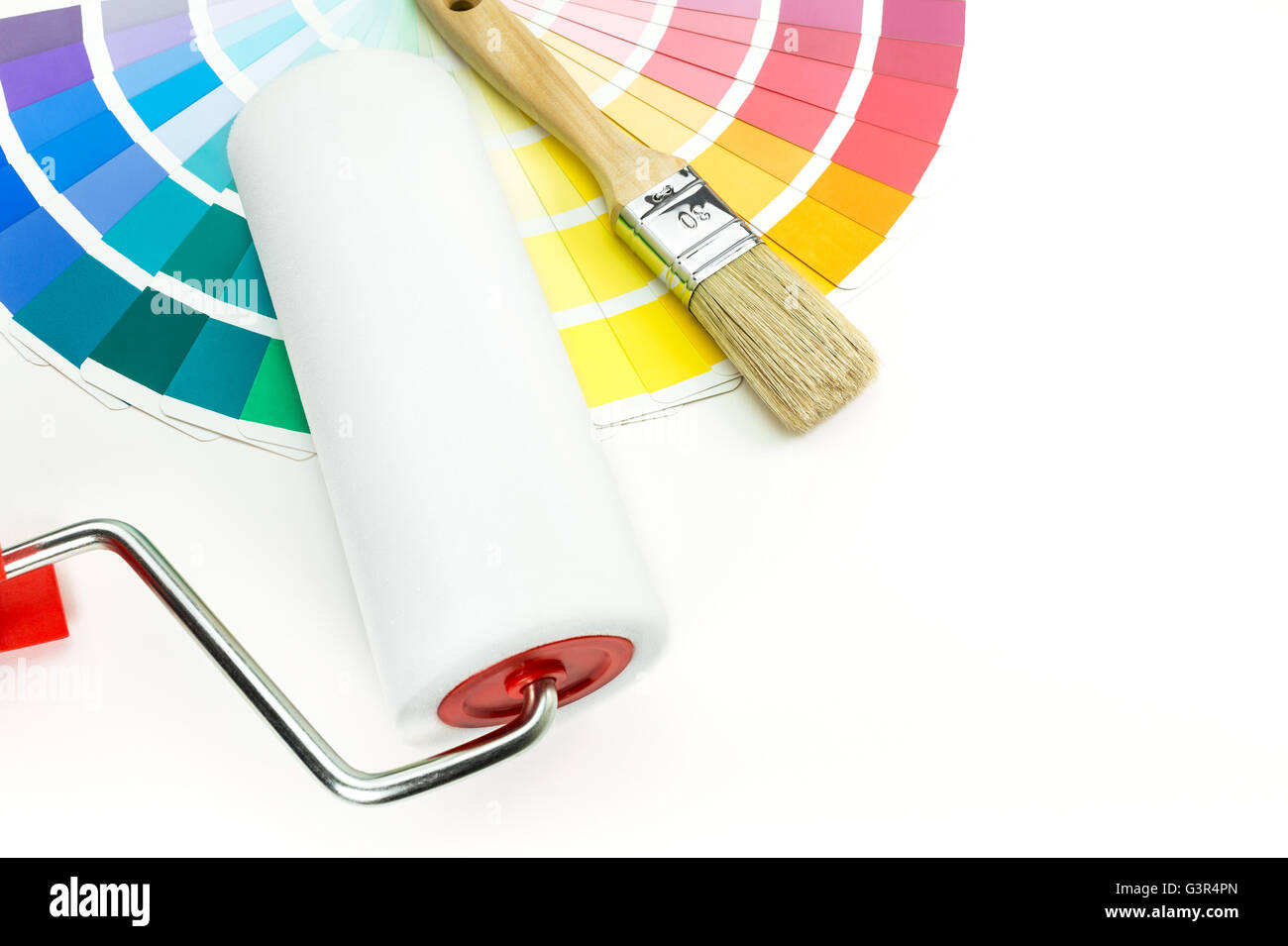 Paint roller, brush and color sample catalog on white background Stock Photo