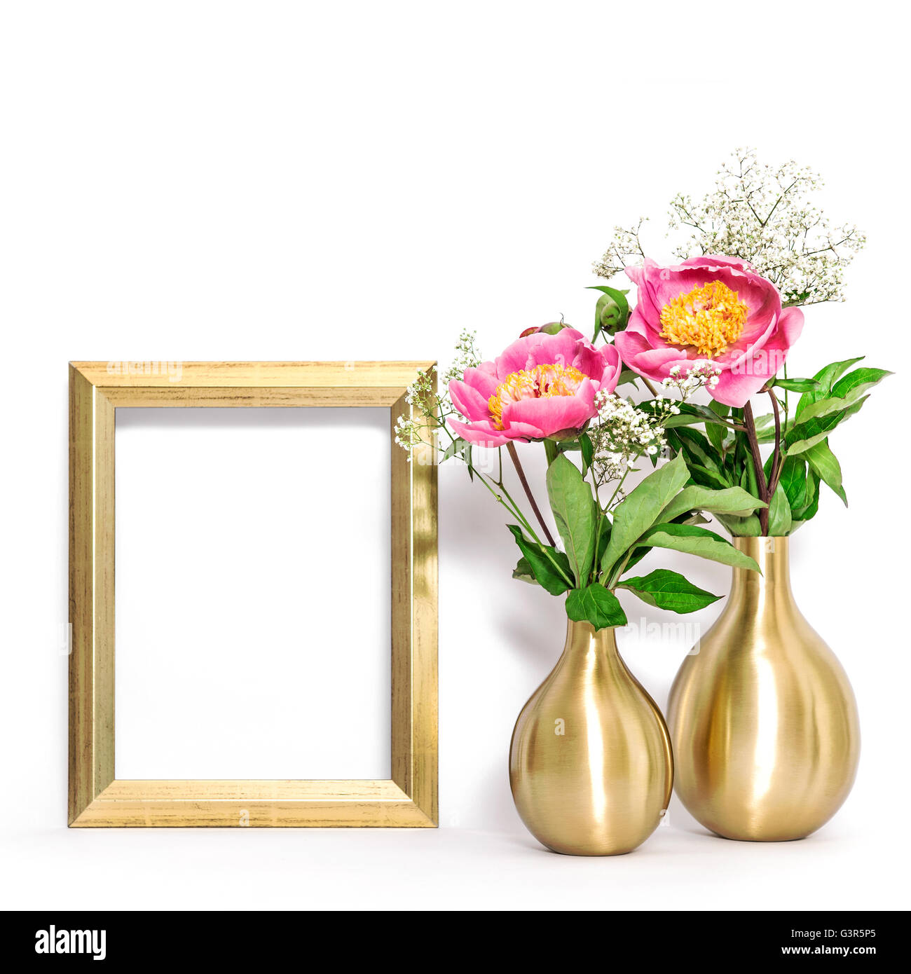 Picture frame and pink peony flowers. Minimal style golden decoration with space for your image Stock Photo