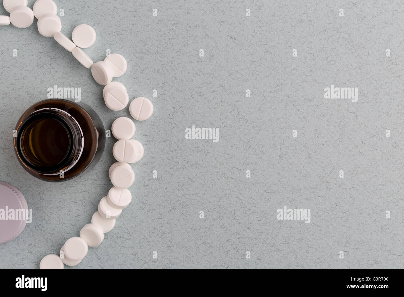 Brown glass pill bottle and white pills Stock Photo