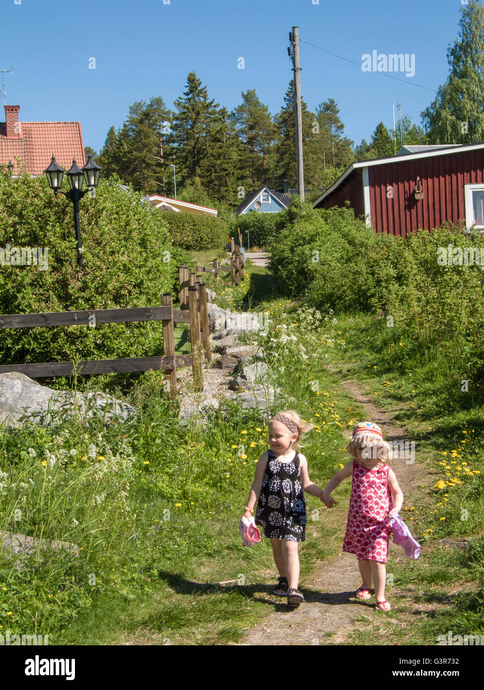 Sweden, Medelpad, Sundsvall, Girls (4-5) walking in countryside holding hands Stock Photo