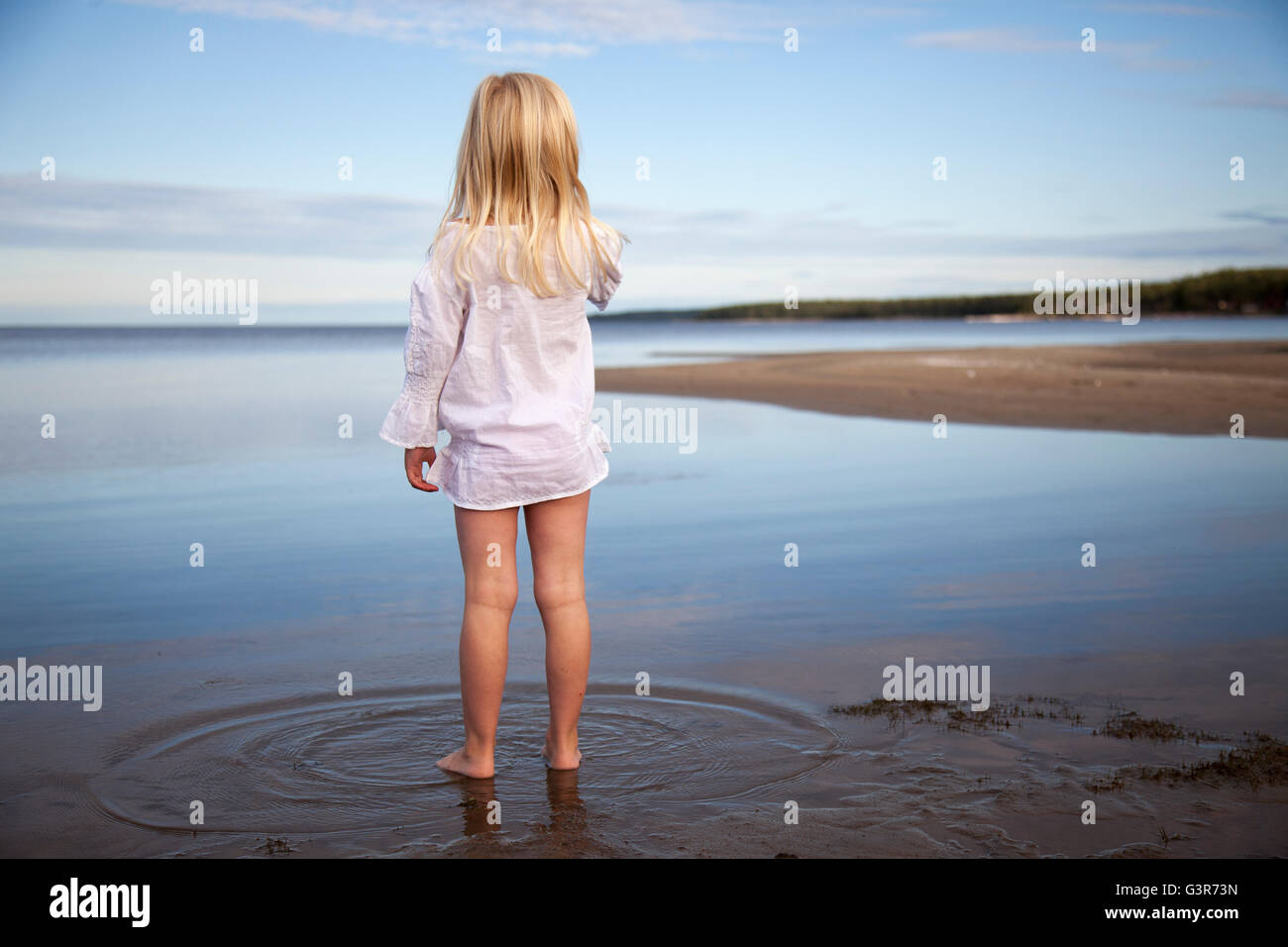Sweden, Medelpad, Juniskarr, Blonde girl (6-7) standing in water Stock Photo