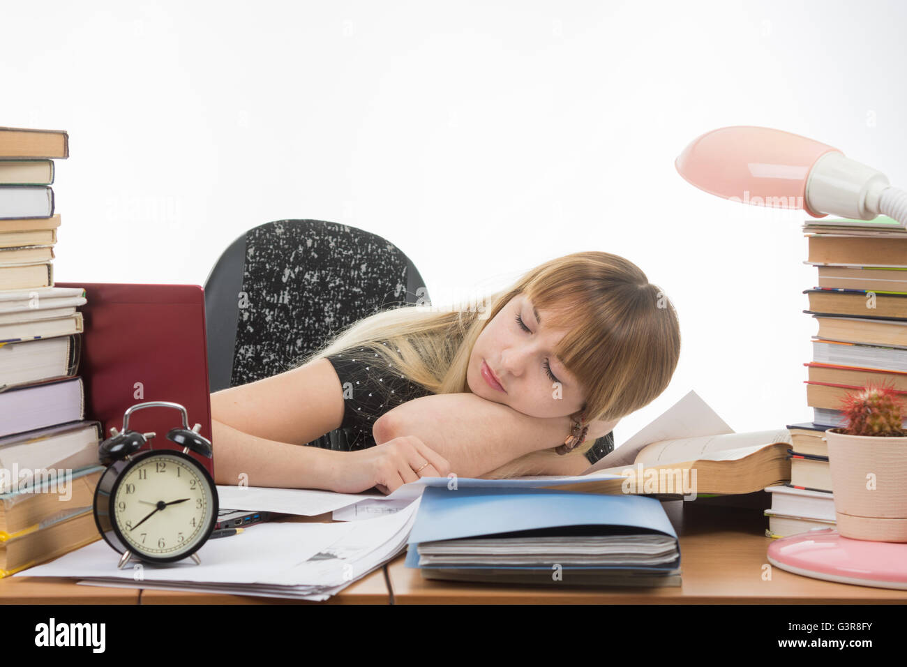 Student fell asleep at the table getting ready to pass the graduation project Stock Photo