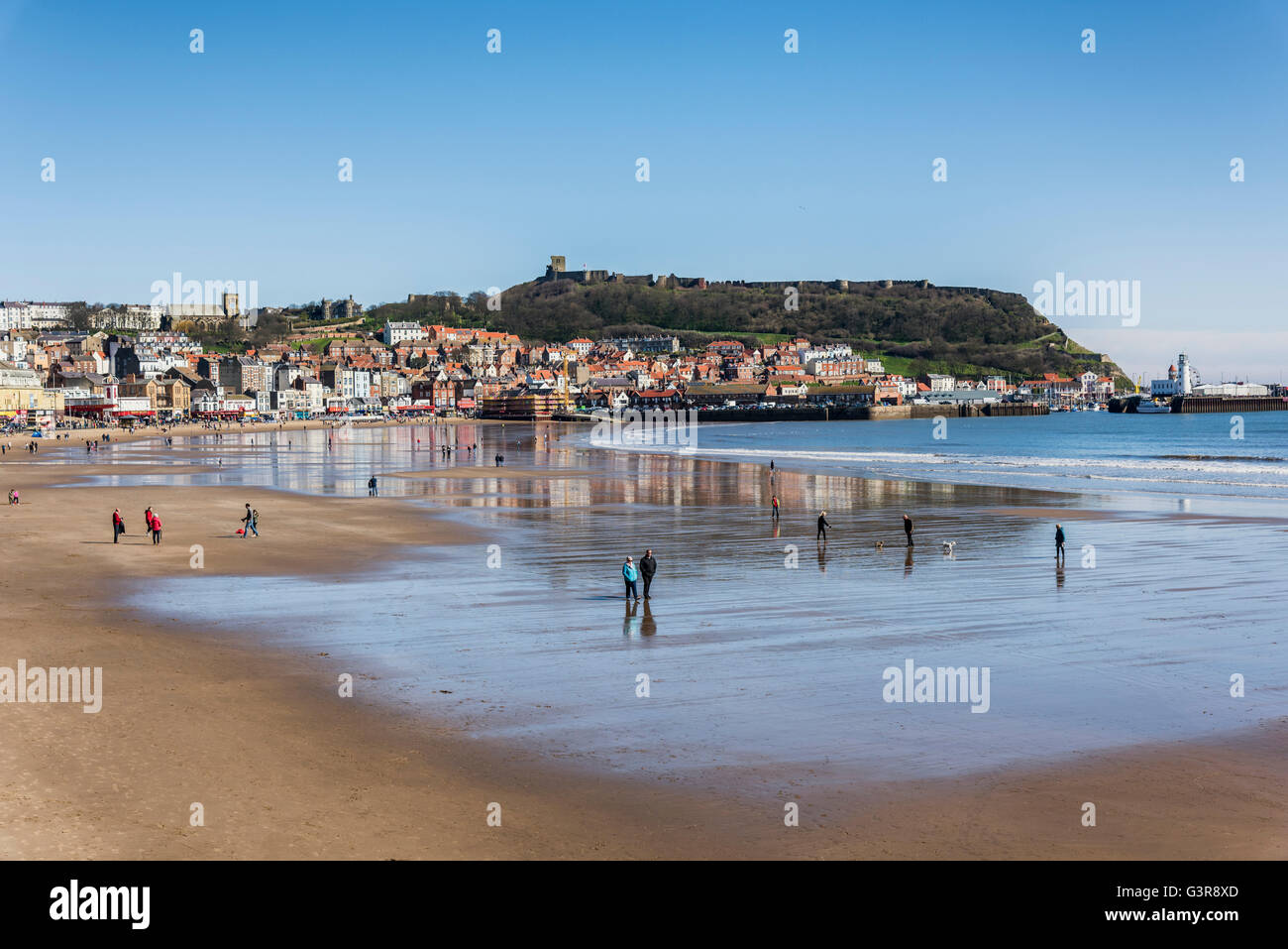 People enjoying a bright, sunny, spring day on Scarborough's south bay beach Stock Photo
