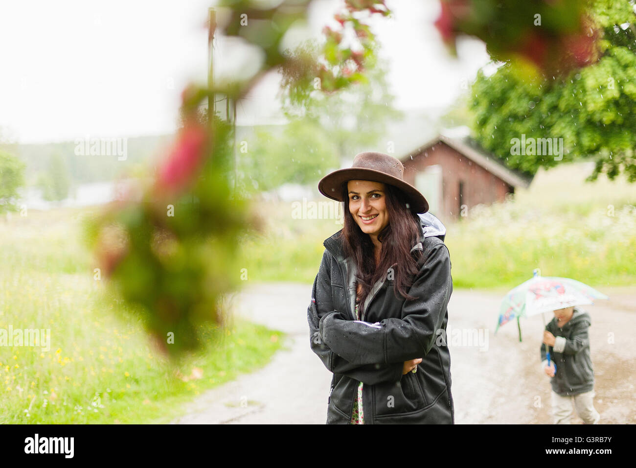 Sweden, Varmland, Filipstad, Gasborn, Horrsjon, Portrait of woman standing in rain Stock Photo