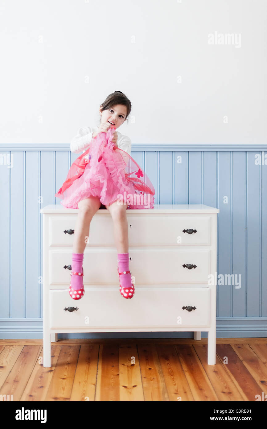 Sweden Little Girl 4 5 In Pink Dress Sitting On Dresser Stock