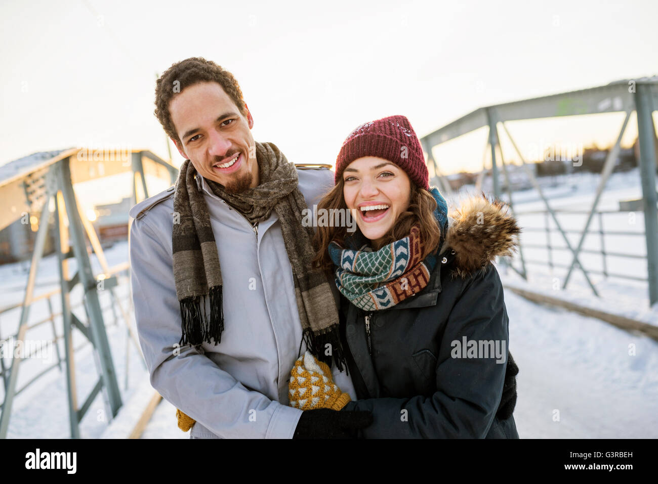 Sweden, Vasterbotten, Umea, Young couple on footbridge in winter Stock