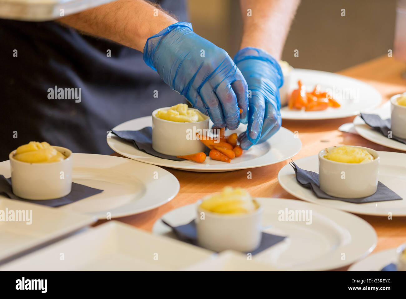 Plating mash potato and carrots dinner at wedding event Stock Photo Alamy