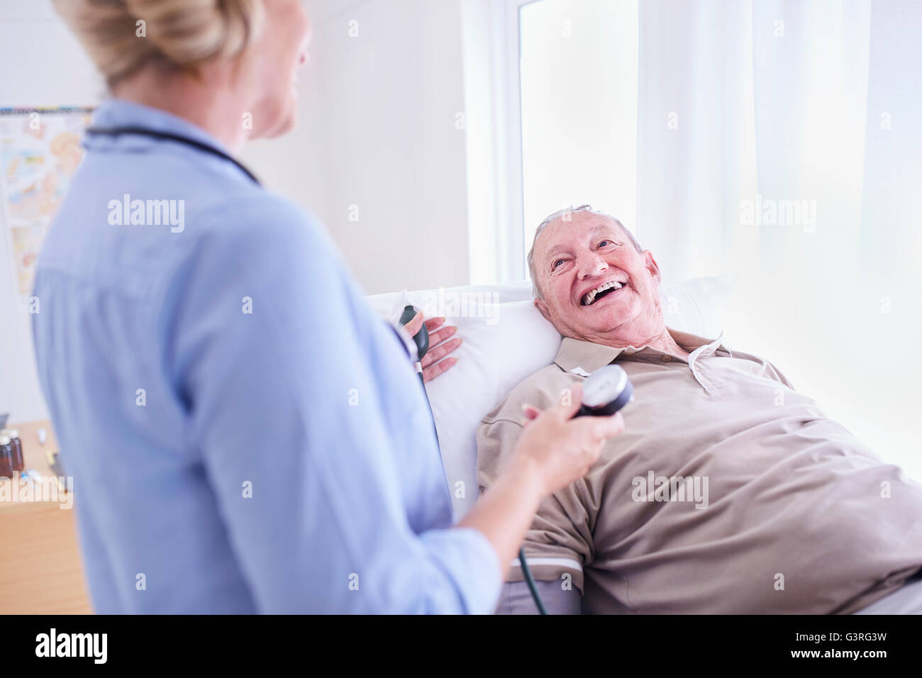 Doctor checking senior man’s blood pressure Stock Photo