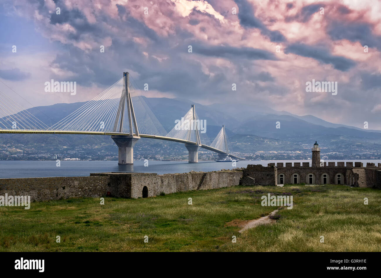 The cable bridge between Rio and Atnirrio, Greece, and the old fortress, at dusk Stock Photo