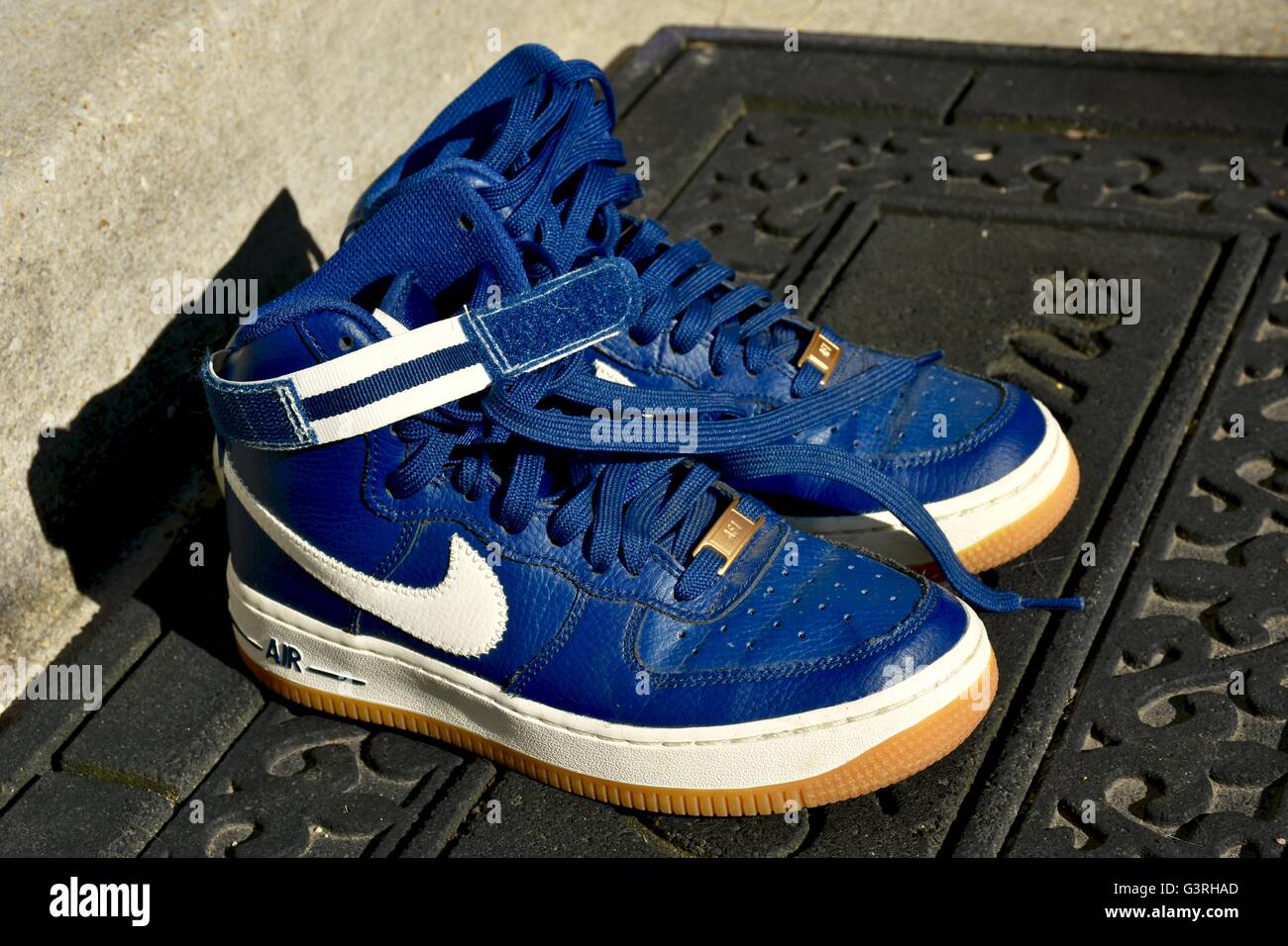 A pair of blue Nike shoes sitting on a door mat in front of a house Stock  Photo - Alamy