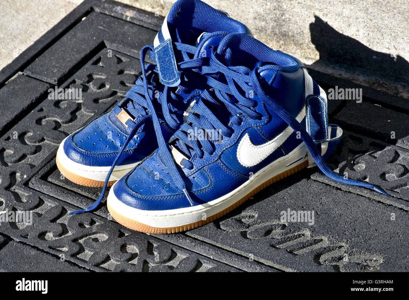 A pair of blue Nike shoes sitting on a door mat in front of a house Stock  Photo - Alamy