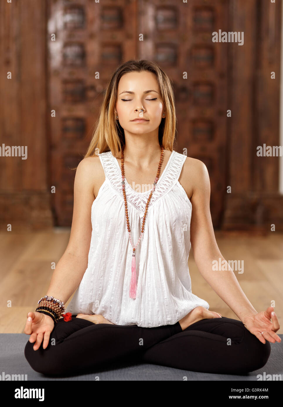 Attractive woman yoga trainer in lotus (padmasana) pose Stock Photo - Alamy