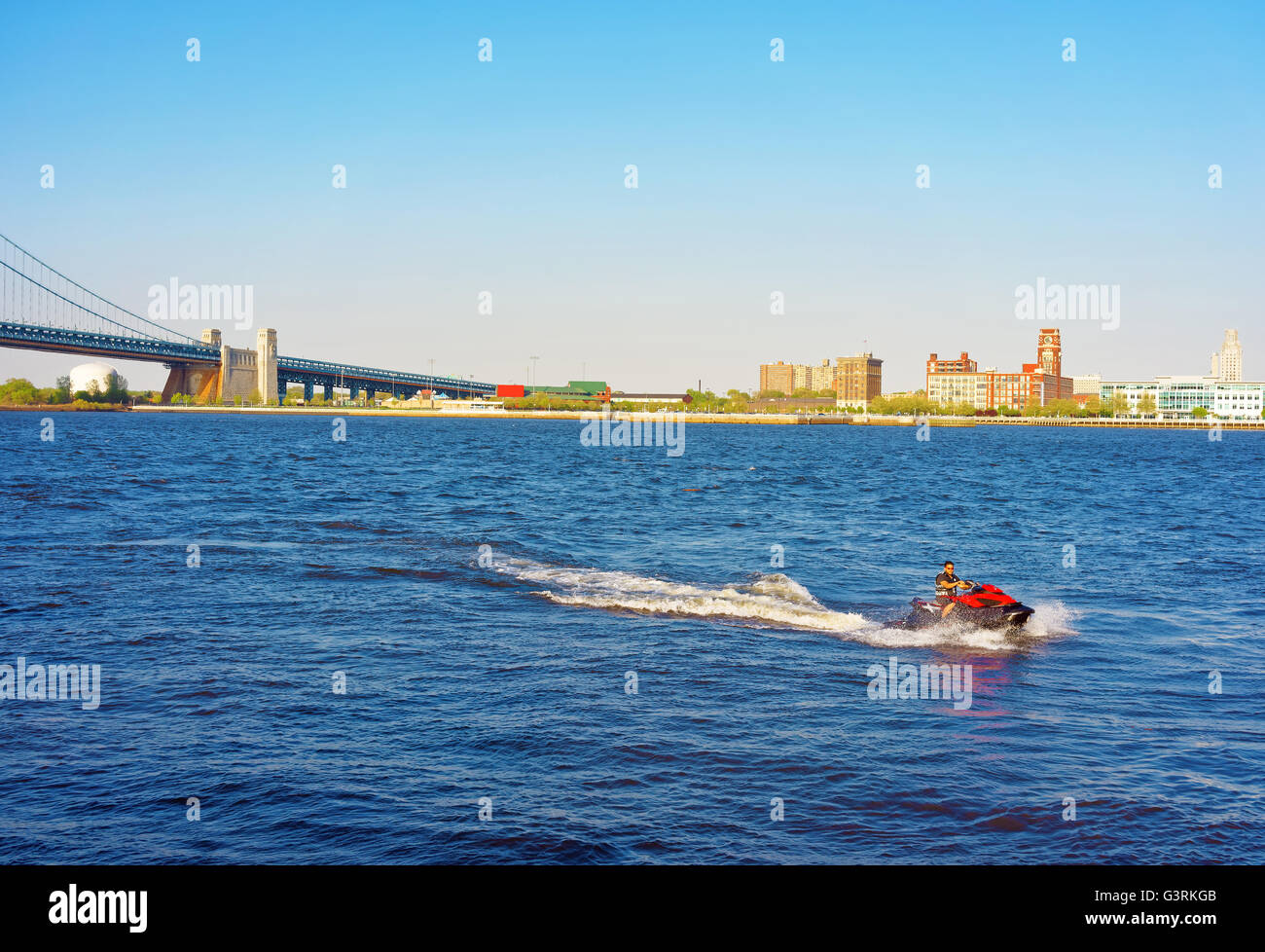 Philadelphia, USA May 5, 2015 Jet boat with a man near Benjamin Franklin Bridge over Delaware