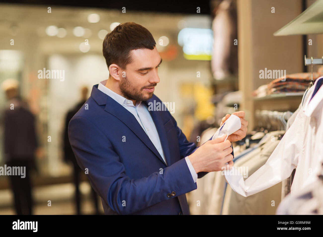 happy young man choosing clothes in clothing store Stock Photo - Alamy