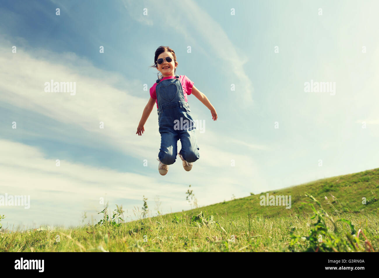 happy little girl jumping high outdoors Stock Photo - Alamy