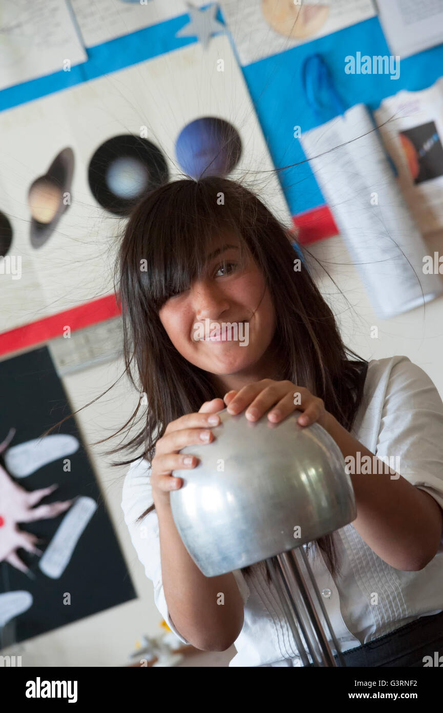 A hair raising schoolgirl using a Van de Graaff generator during a