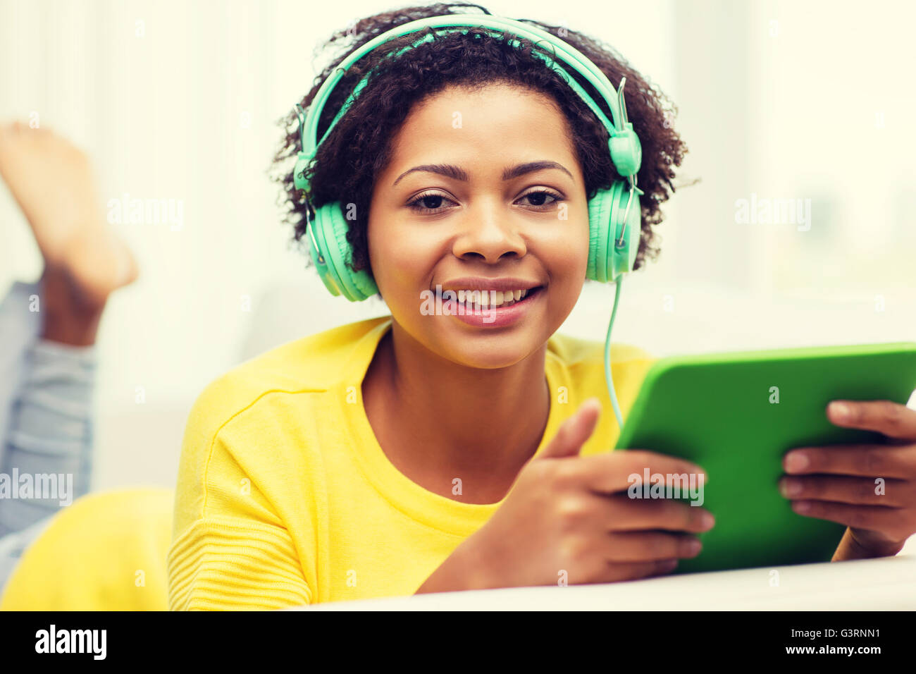 happy african woman with tablet pc and headphones Stock Photo - Alamy