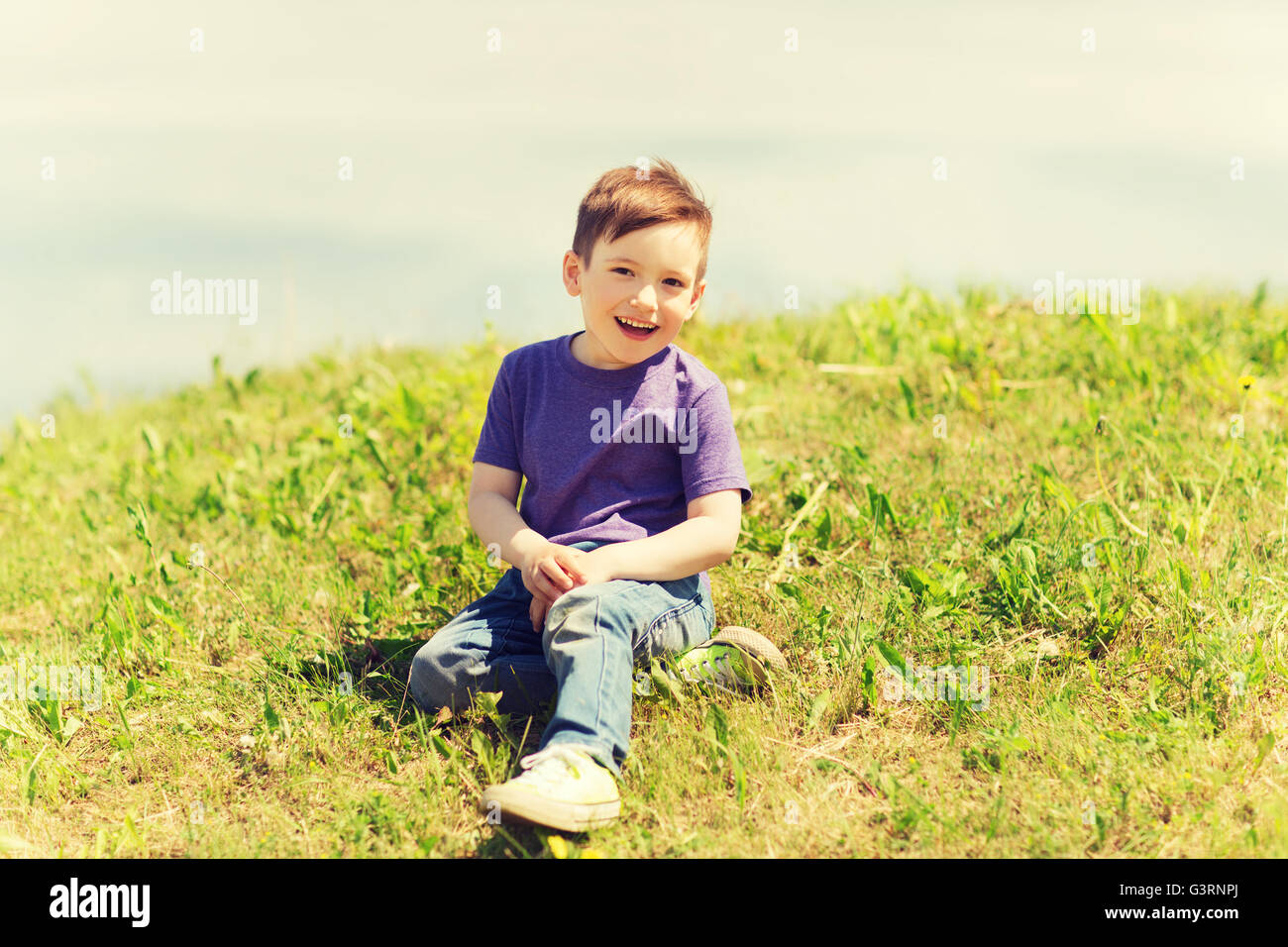 Boy sitting on grass hi-res stock photography and images - Alamy