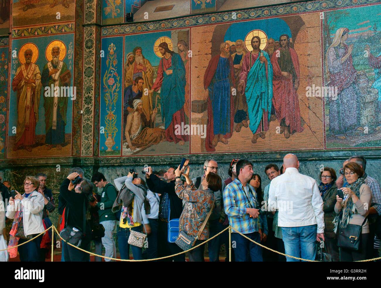 Saint Petersburg Russia. Russian Orthodox Church of the Saviour on Spilled Blood. Tourists view interior mosaics of saints Stock Photo