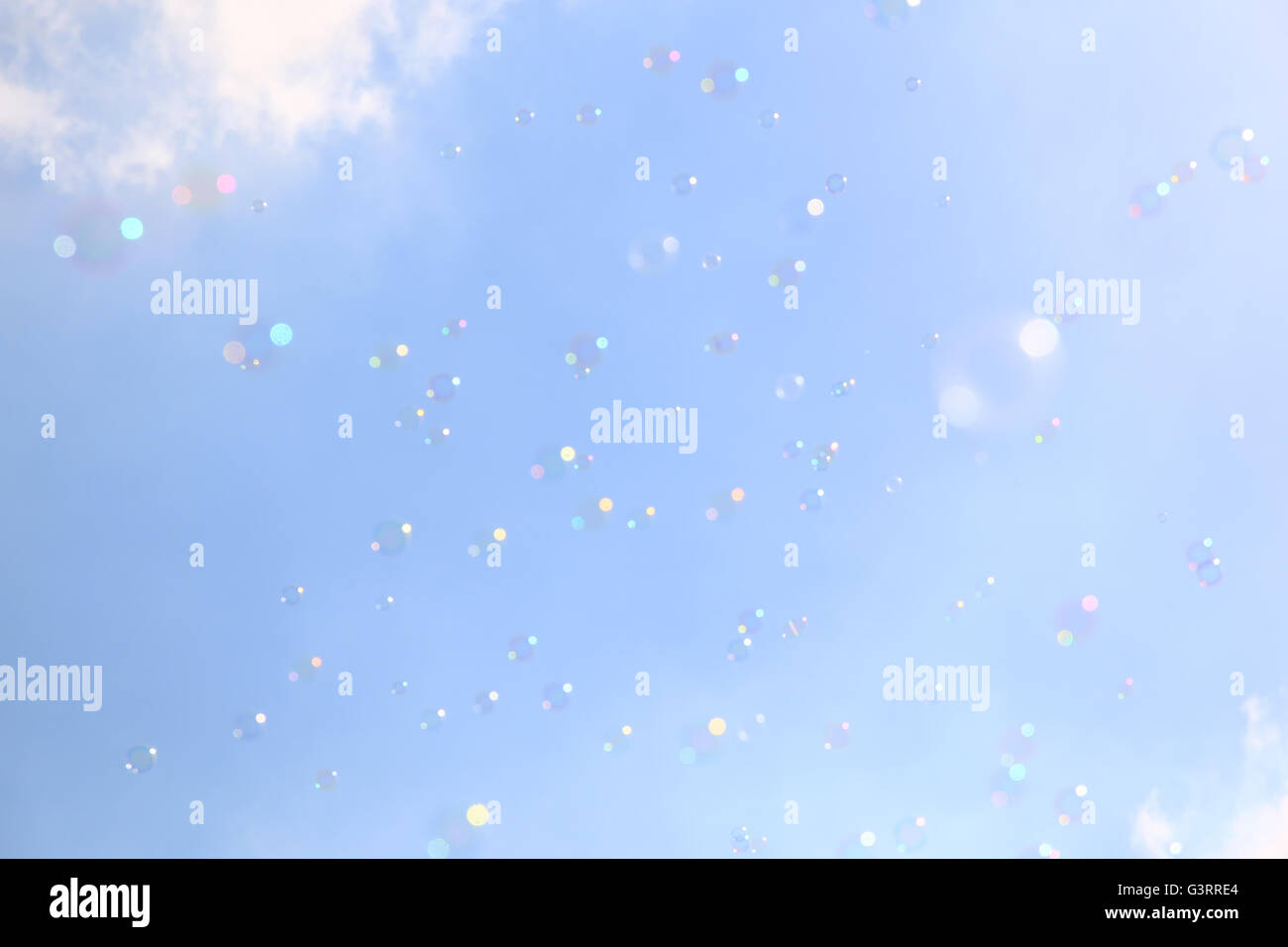 Soap bubbles floating in the air against soft clouds and sky. filtered ...