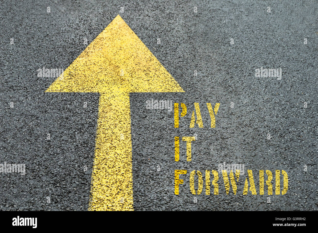 Yellow forward road sign with Pay It Forward word on the asphalt road. Business concept. Stock Photo