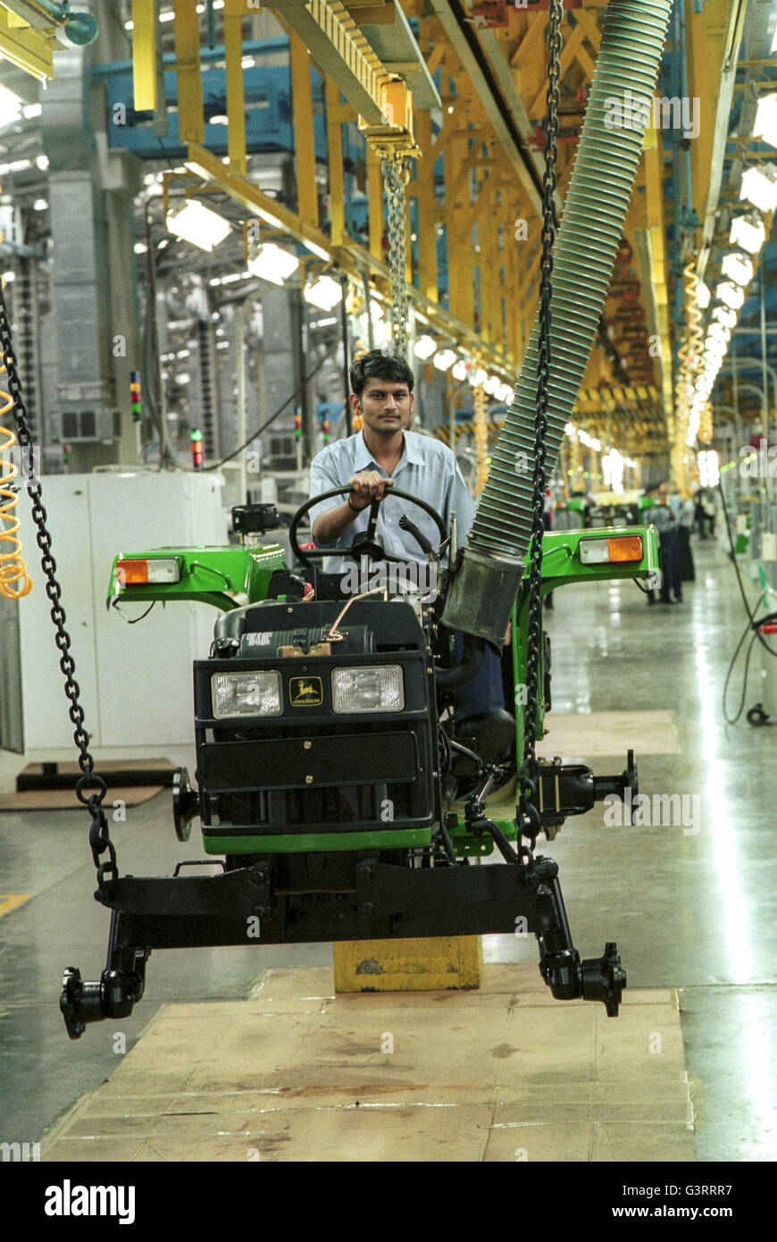 INDIA, Pune, American company John Deere tractor factory, employee working at assembly line , production of John Deere tractor 5103 for the indian market and for export to africa, asia Stock Photo