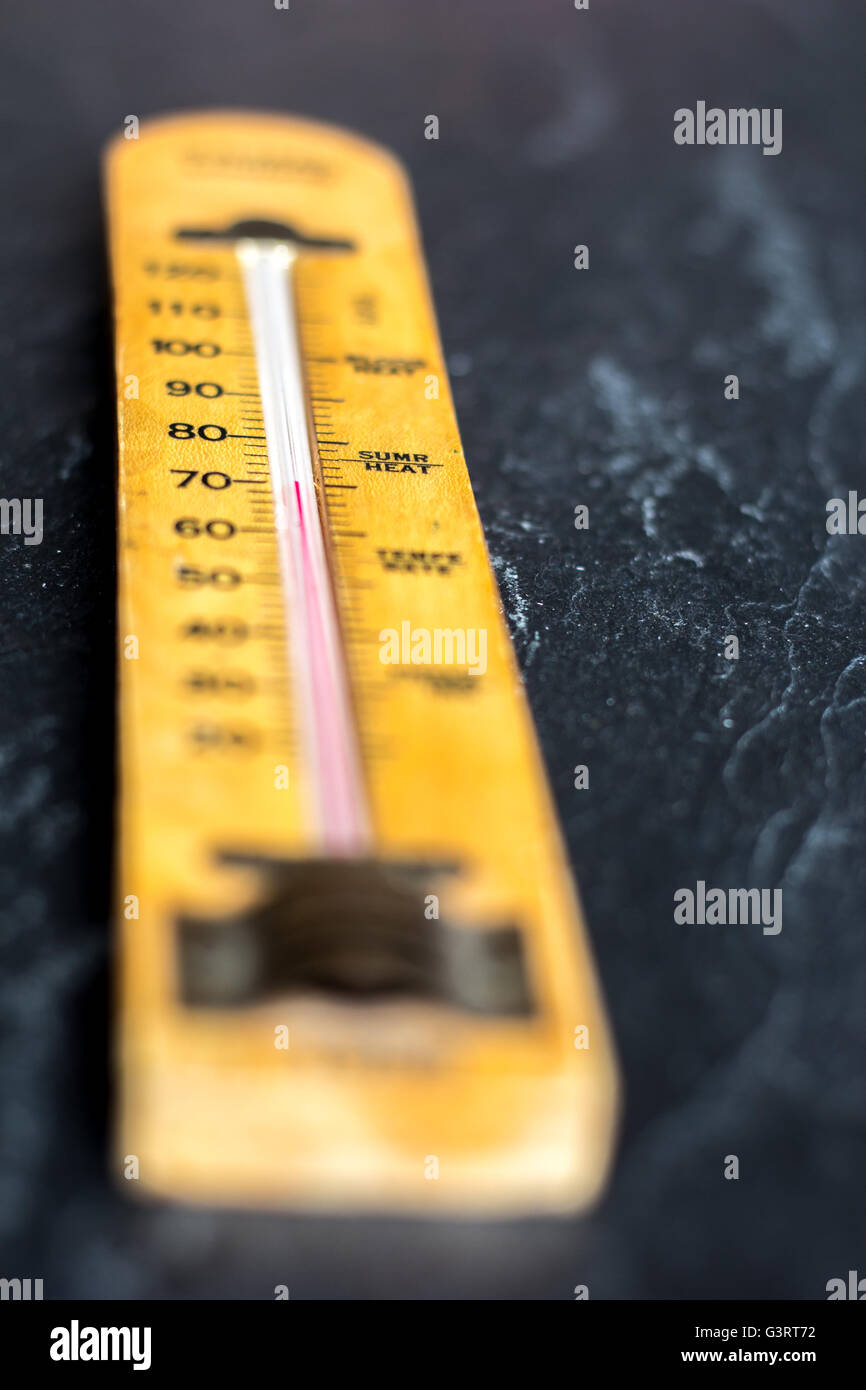 Old wooden thermometer on slate background Stock Photo