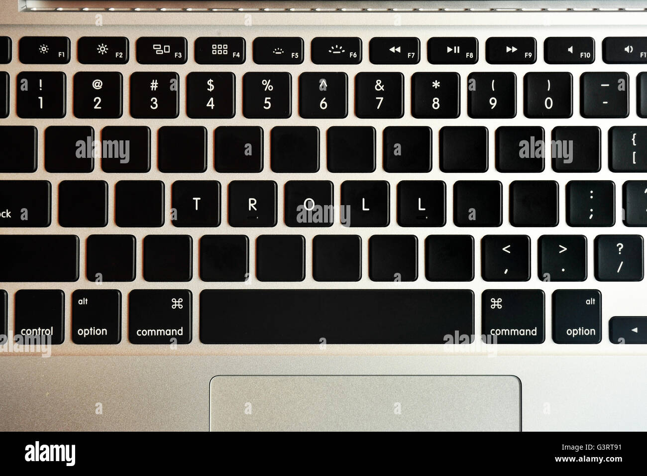 Troll written on the keyboard of a MacBook Pro. Stock Photo