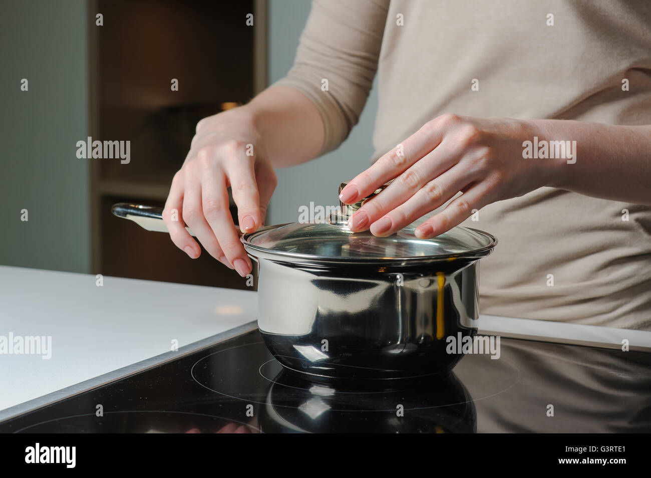 Person removing lid from cooking pot Stock Photo Alamy