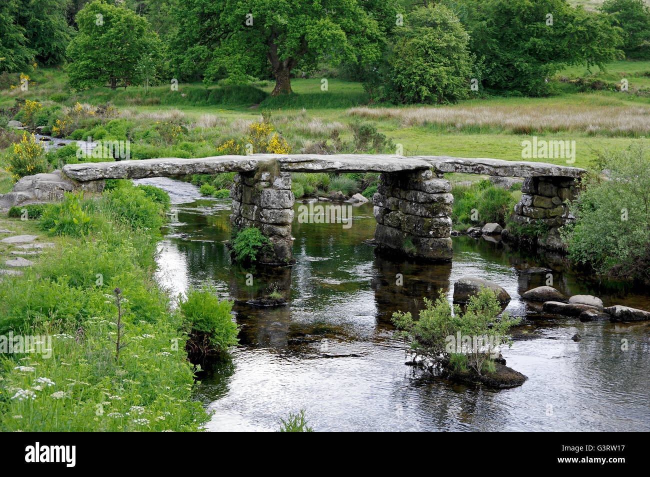 13th century clapper bridge over the East Dart River on Dartmoor. Stock Photo