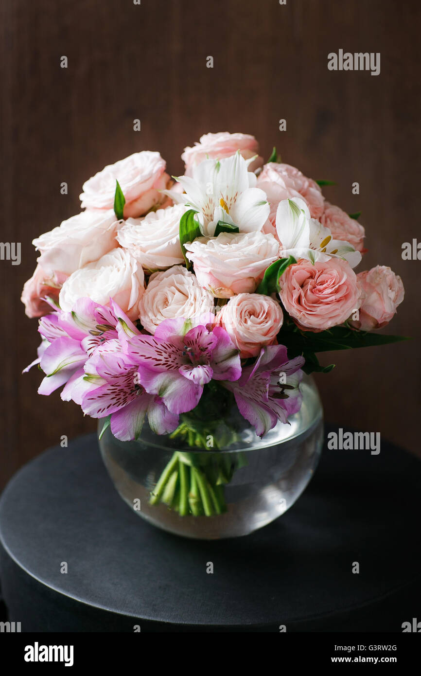 still life. a wooden antique table, glass vase with Mixed bouquet. beautiful flowers Stock Photo