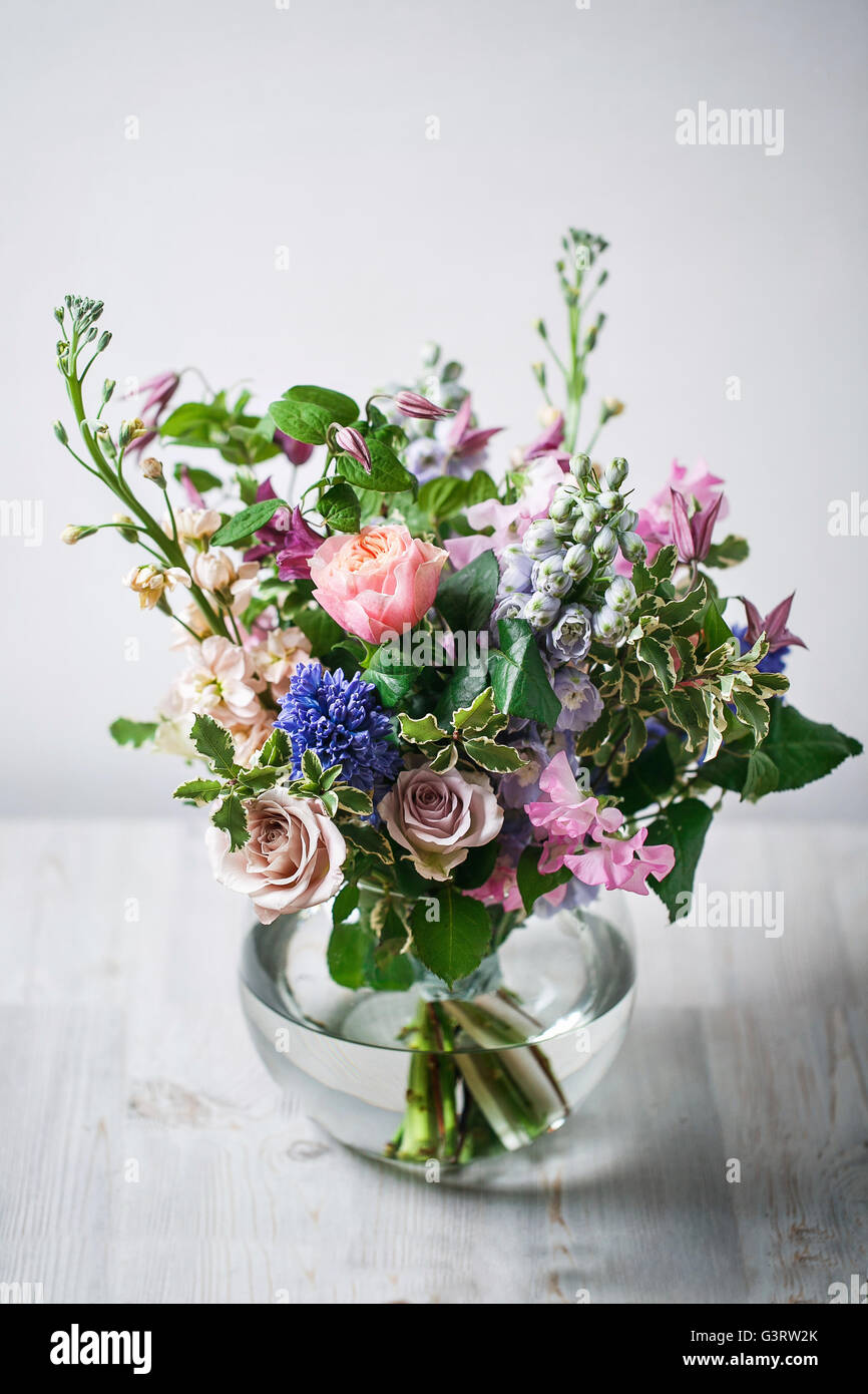 still life. a wooden antique table, glass vase with Mixed bouquet. beautiful flowers Stock Photo