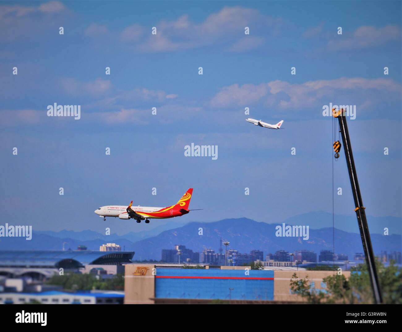Planes. Plane coming into land and another going in a different direction in busy Beijing airport. Stock Photo