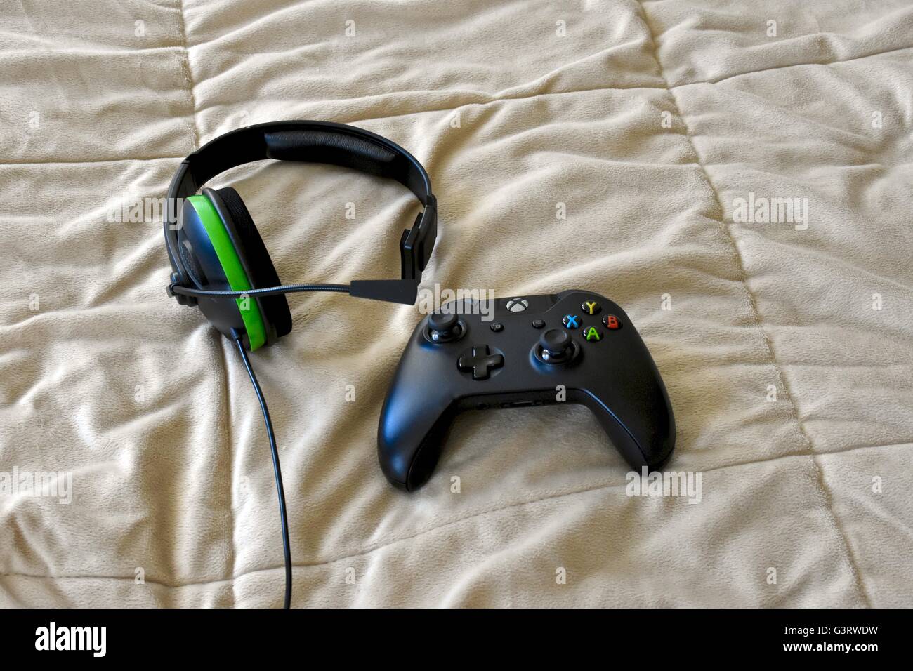 An Xbox One controller and headset laying on a bed Stock Photo - Alamy