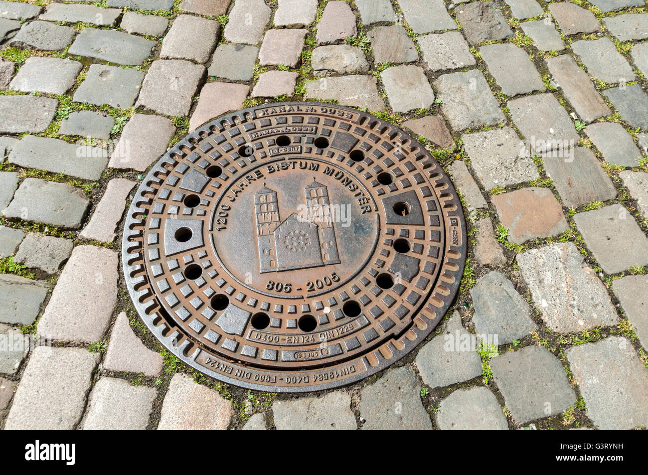 Decorative man-hole cover on cobbled street in Münster, NRW, Germany. Stock Photo