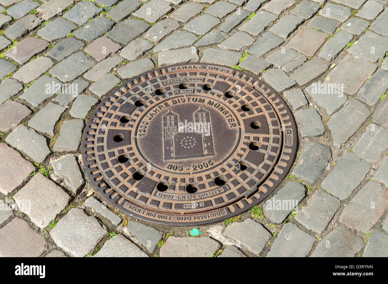 Decorative man-hole cover on cobbled street in Münster, NRW, Germany. Stock Photo