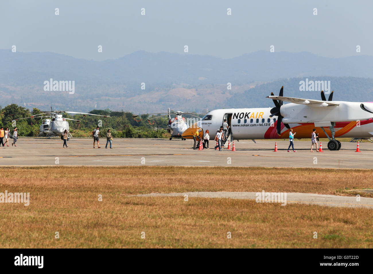 Mae Sot, Thailand DEC 20, 2014: Unidentified group of people walked to BOMBARDIER Q400 NextGen 'Nok Kao Poon' of Nok Air at Mae  Stock Photo