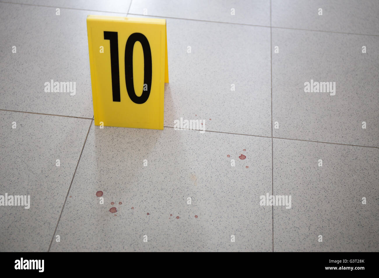 evidence marker at bloodstain on room floor in crime scene Stock Photo