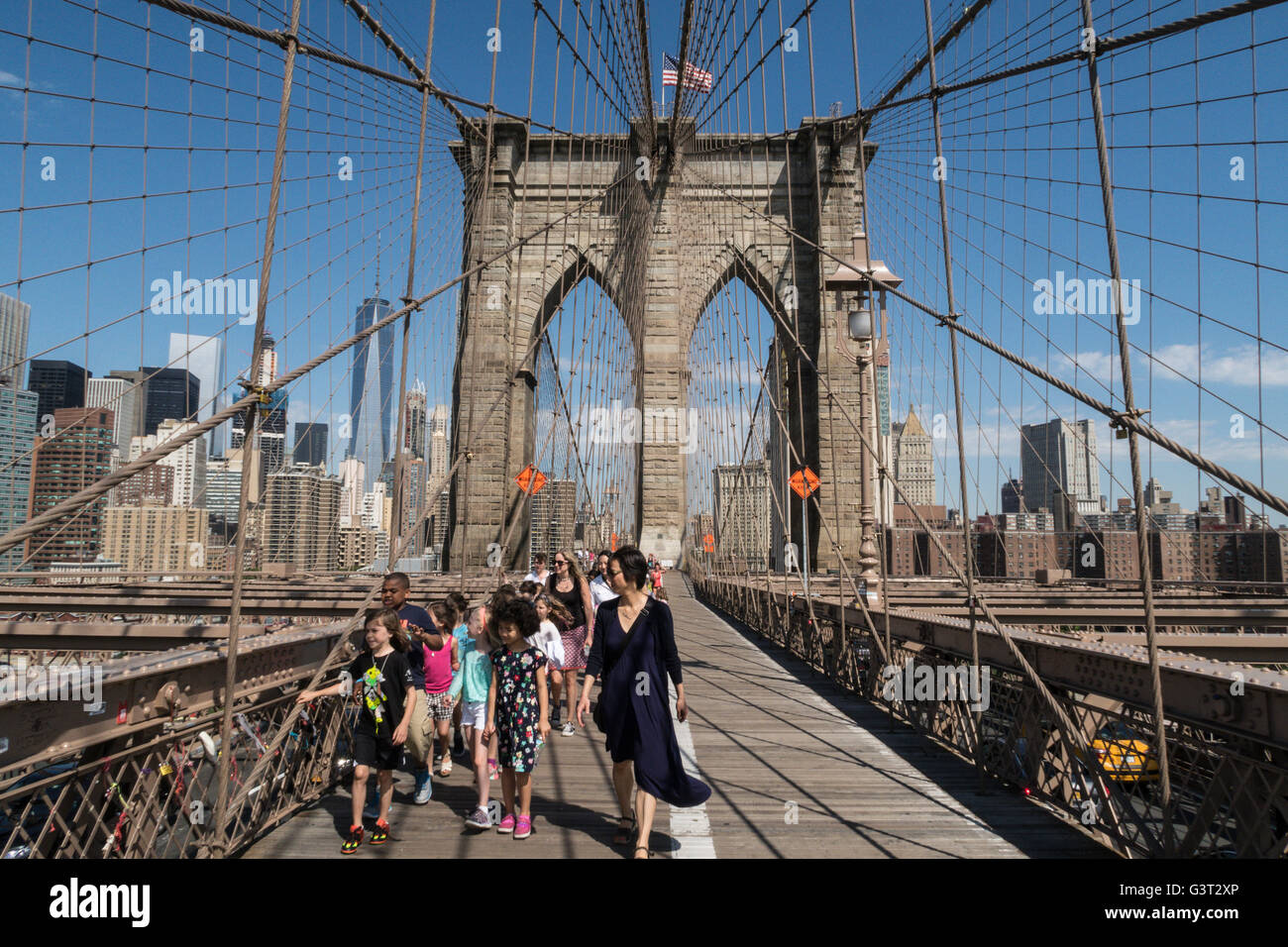 A School Group Walking on the Brooklyn Bridge with New York City in the background, USA  2016 Stock Photo