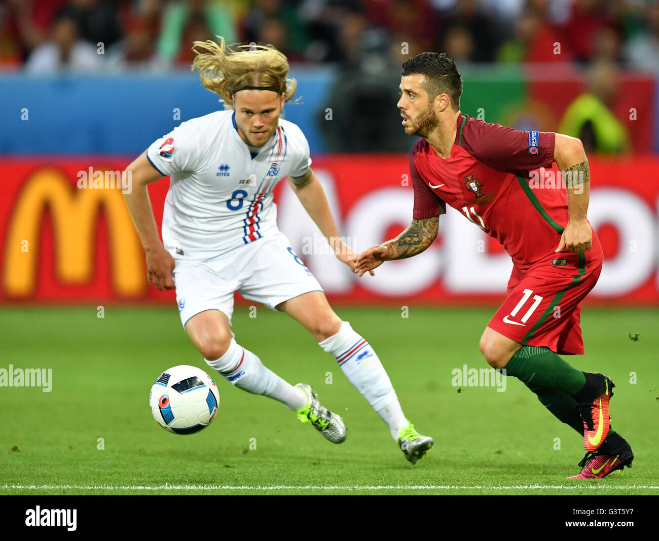 Saint-Etienne, France. 14th June, 2016. Vieirinha (R) of Portugal and Birkir Bjarnason of Iceland vie for the ball during the UEFA Euro 2016 Group F soccer match Portugal vs. Iceland at Stade Geoffroy Guichard in Saint-Etienne, France, 14 June 2016. Photo: Uwe Anspach/dpa/Alamy Live News Stock Photo