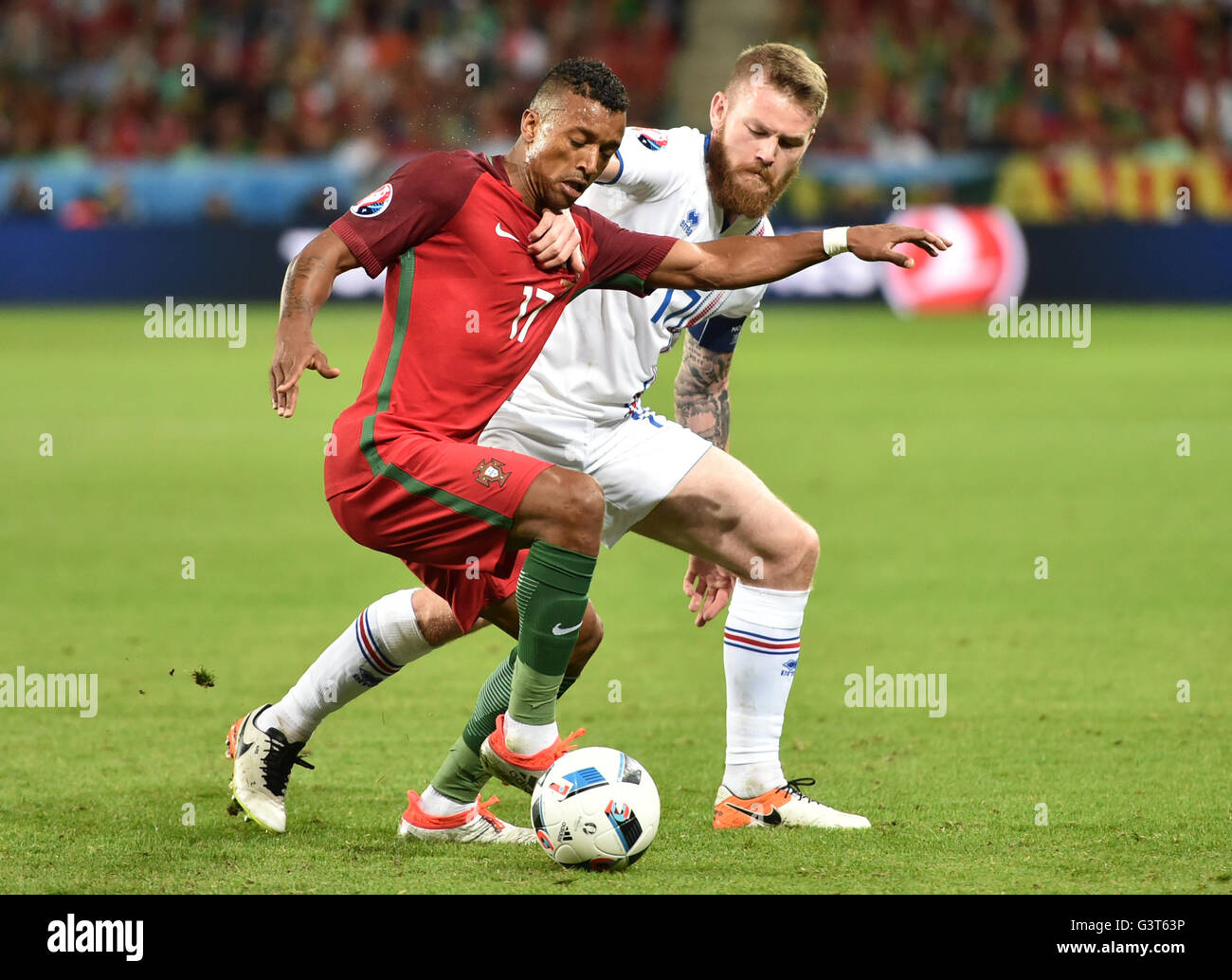 Saint-Etienne, France. 14th June, 2016. Nani (L) of Portugal and Aron Gunnarsson of Iceland vie for the ball during the UEFA Euro 2016 Group F soccer match Portugal vs. Iceland at Stade Geoffroy Guichard in Saint-Etienne, France, 14 June 2016. Photo: Uwe Anspach/dpa/Alamy Live News Stock Photo