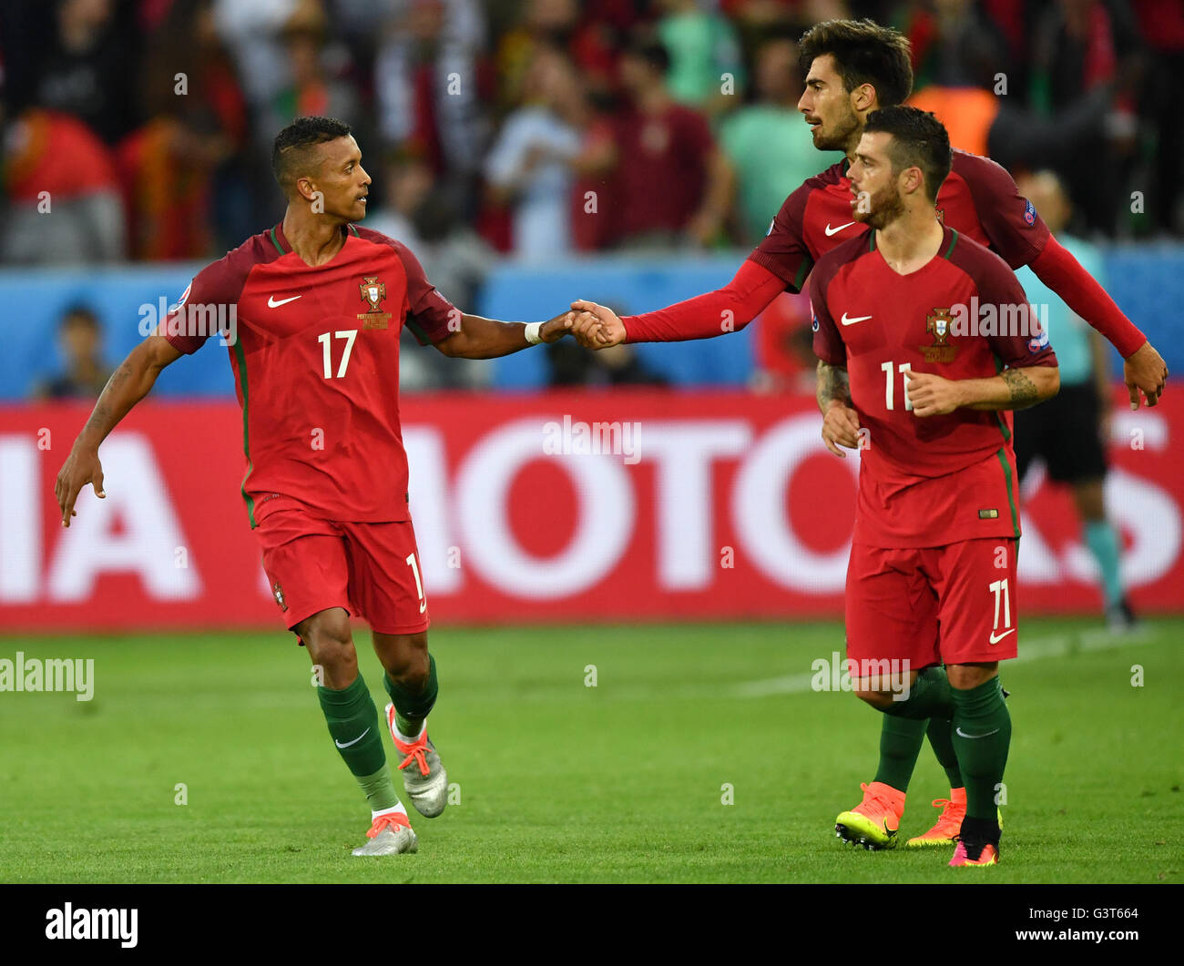 Saint-Etienne, France. 14th June, 2016. Nani (L) of Portugal celebrates after scoring the leading goal with teammate Andre Gomes and Vieirinha (R) during the UEFA Euro 2016 Group F soccer match Portugal vs. Iceland at Stade Geoffroy Guichard in Saint-Etienne, France, 14 June 2016. At left dejected Birkir Bjarnason of Iceland. Photo: Uwe Anspach/dpa/Alamy Live News Stock Photo