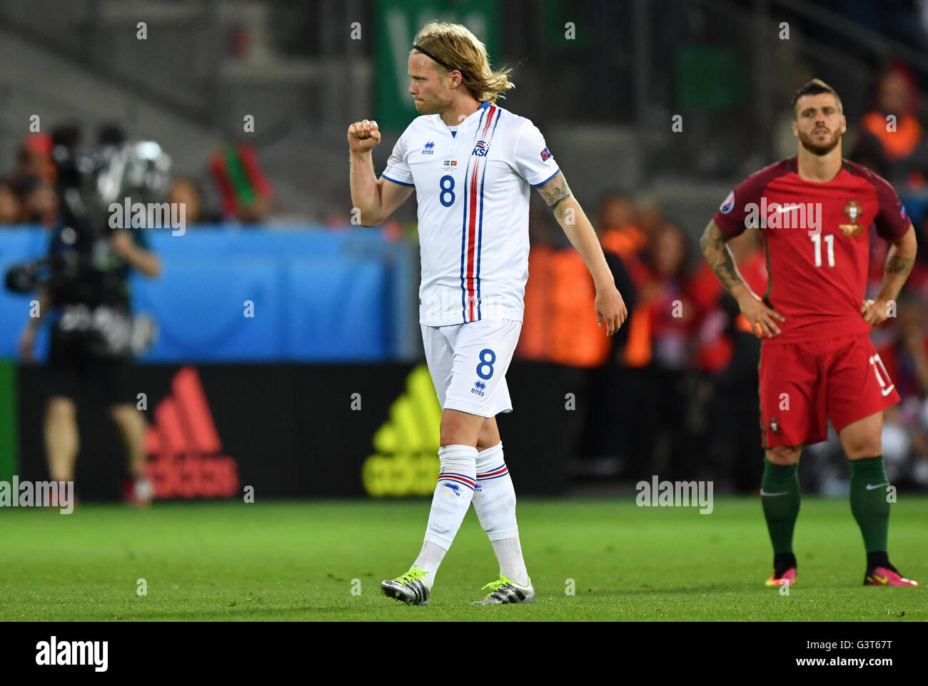 Saint-Etienne, France. 14th June, 2016. Birkir Bjarnason (L) of Iceland celebrates after scoring the equalizer during the UEFA Euro 2016 Group F soccer match Portugal vs. Iceland at Stade Geoffroy Guichard in Saint-Etienne, France, 14 June 2016. Vieirinha (R) of reacts. Photo: Uwe Anspach/dpa/Alamy Live News Stock Photo